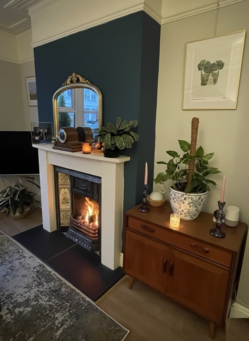 Teal fireplace wall with lit fire and curated mantle accessories