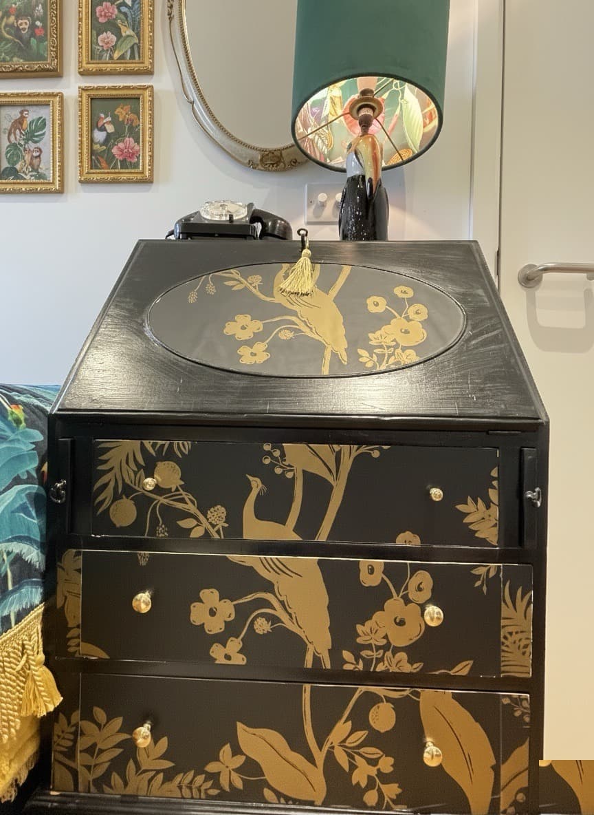 Black and gold chinoiserie cabinet with peacock motif and a tassel, styled in a Levant House interior